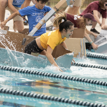 Students in cardboard canoe race for the First Year Olympic event